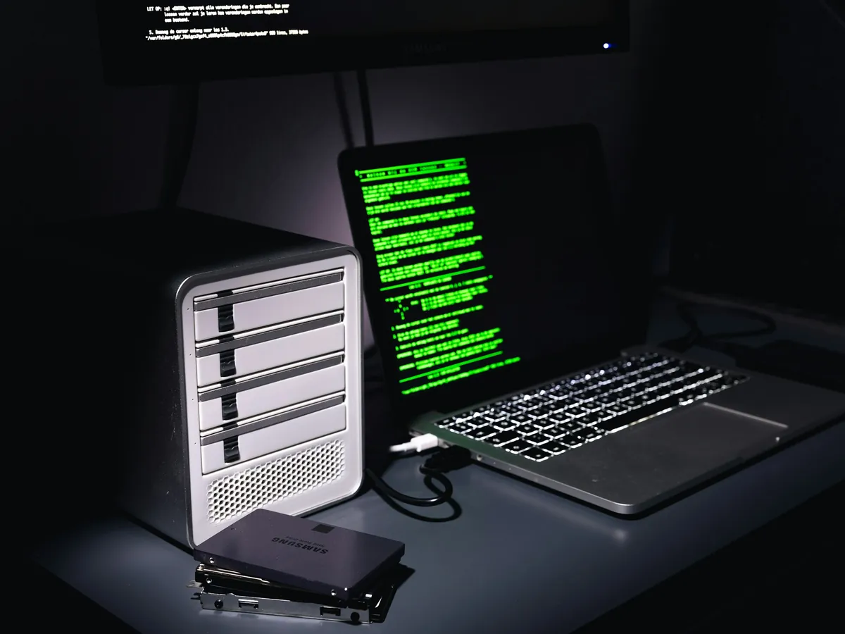 A backup appliance and drives beside a laptop